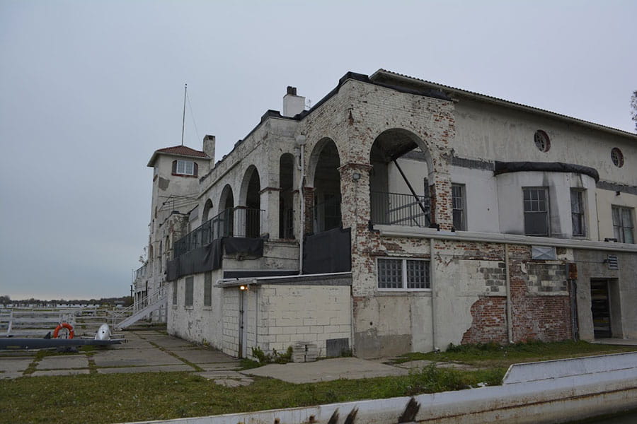 Outside of building with concrete spalling and exposed brick.