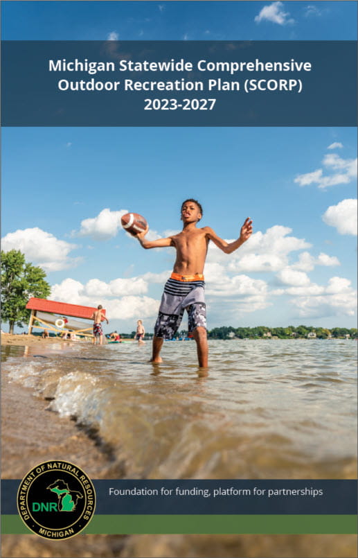 Cover of the 2023 SCORP plan, showing a child standing in the water at a beach throwing a football on a sunny summer day