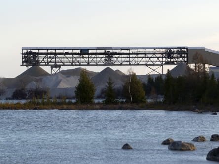 a waterbody in the foreground with a mining operation in the background