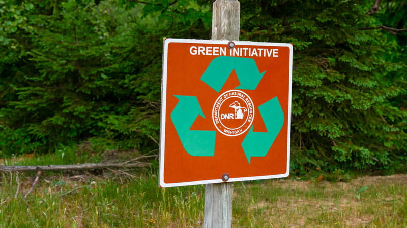 Sign with the words Green Initiatives, green recycling arrows, and the DNR logo