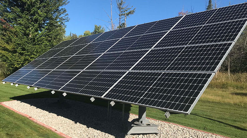A group of solar panels on the ground soak up the energy from the sun