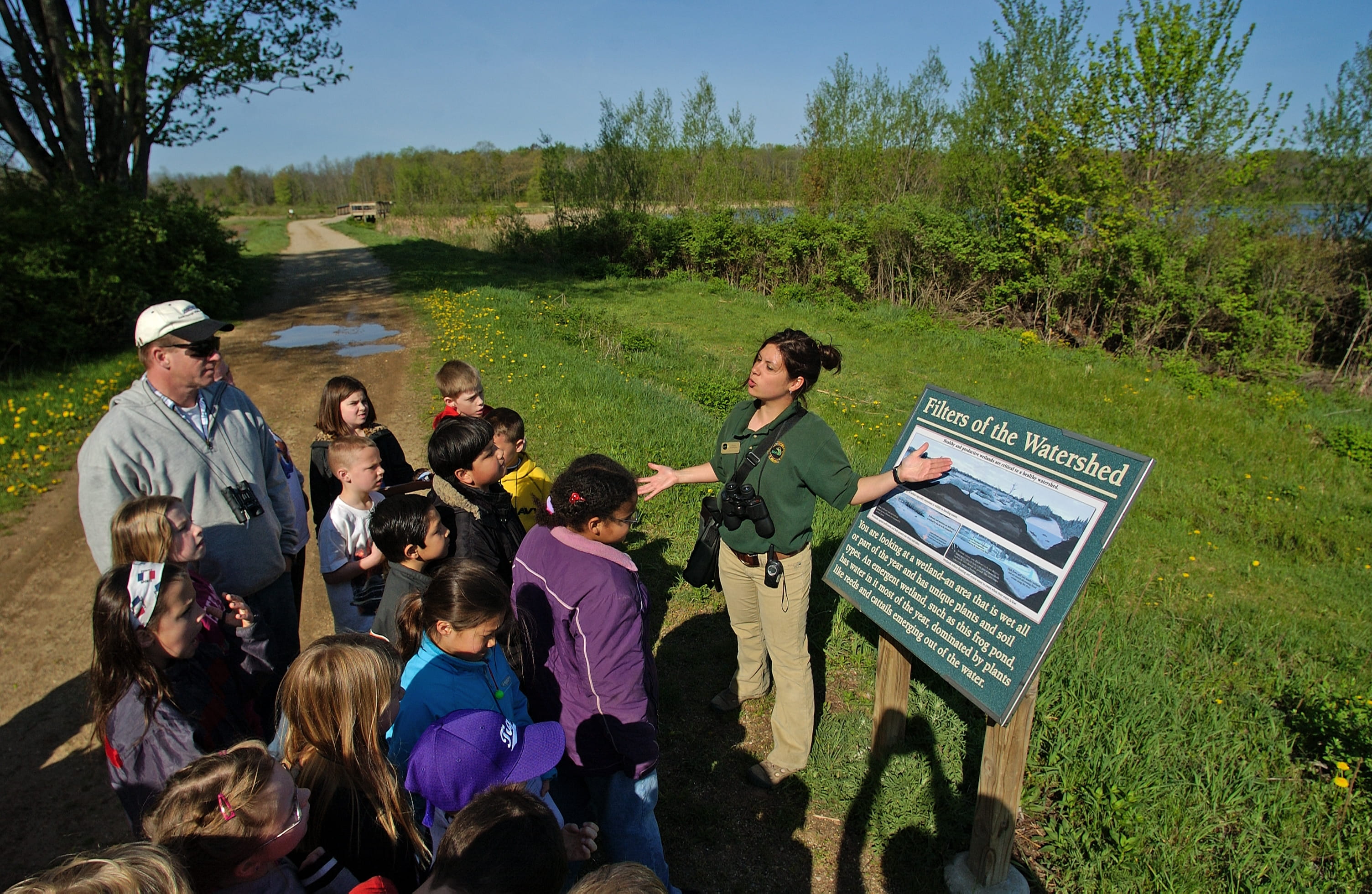 A group listens to an educator during a hatchery tour at Wolf Lake. 