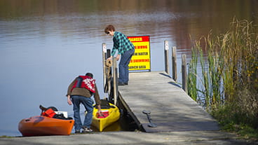 family launching kayaks at a pier