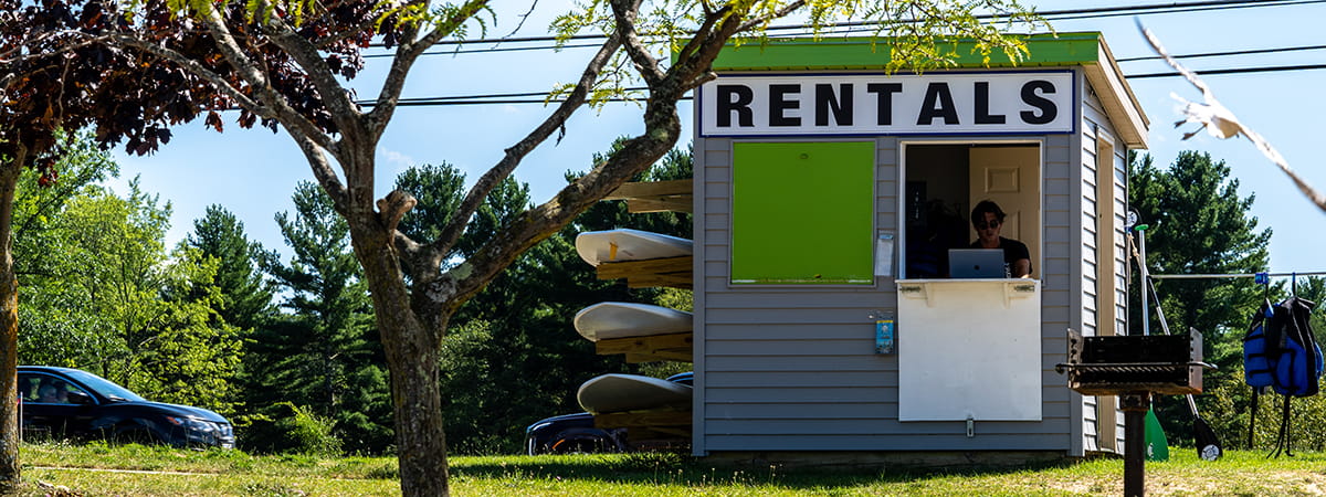 small building with rentals signs and kayaks