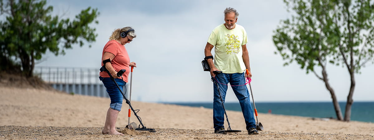 two visitor metal detecting along the beach