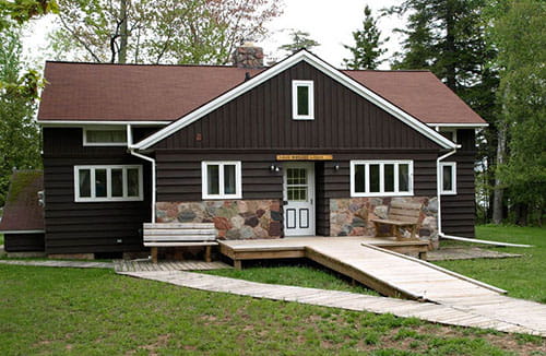 lodge with brown siding and sidewalk leading up to front door