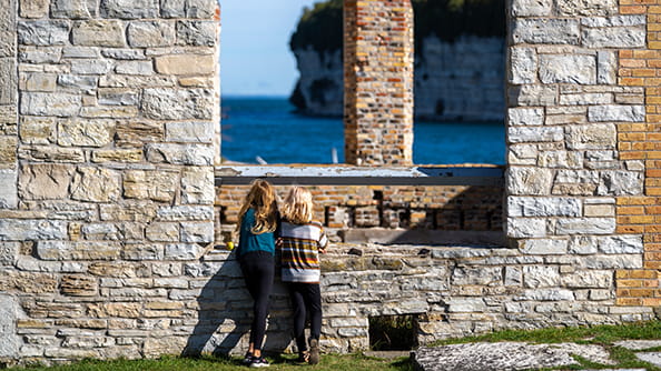 two kids looking out window of historic building at Fayette Historic State Park