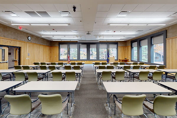 tables and chairs in rows, wood-paneled walls