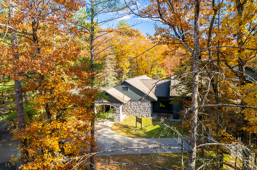 bird's eye view of stone-flagged building surrounded by trees with orange leaves