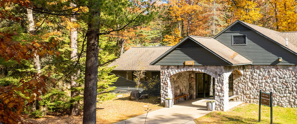stone building with walkway, fall leaves in background