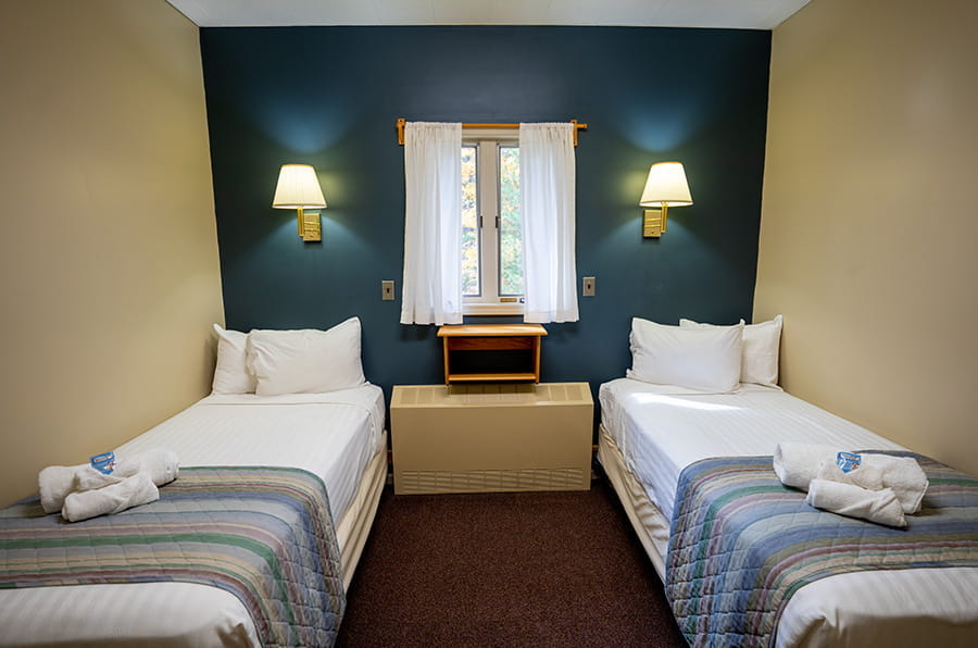 two twin beds, night stand and wall lights