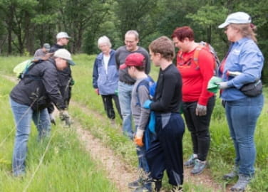 A group of volunteers receive instructions for a workday at a trail