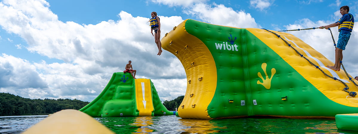 kid jumping off inflatable water structure