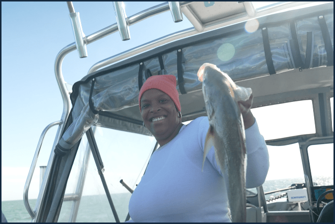 Video thumbnail showing woman on boat holding up fish