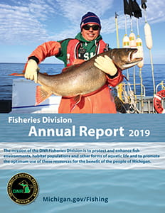 Shawn Sitar, Fisheries Research Biology Specialist, from the Marquette Research Station, holds a large lake trout captured as part of a survey in Lake Superior