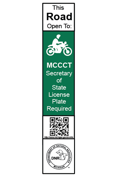 A green and white rectangular sign with a motorcycle on it indicating the road is open to licensed motorcycles