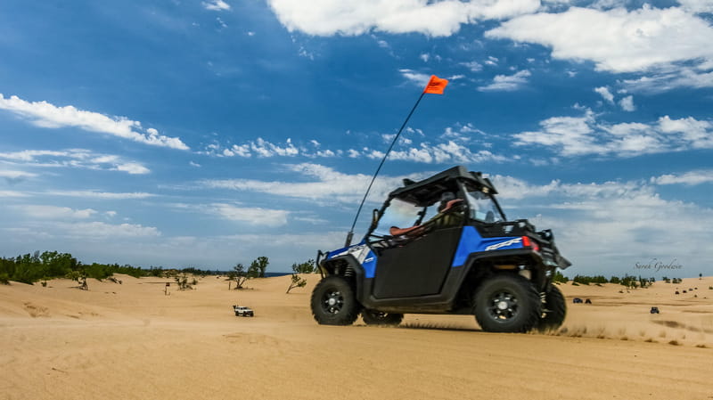 An ORV with an orange flag rides the dunes at Silver Lake ORV Area