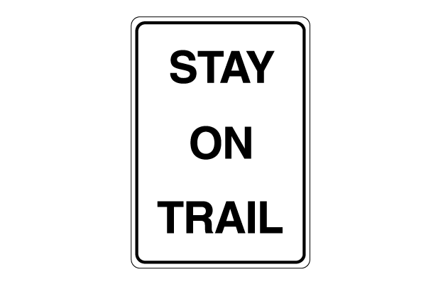White rectangular sign with black text that reads "Stay on trail"