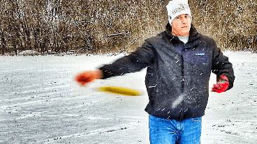 A person plays disc golf in the snow