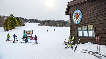 The lodge at the Porkies ski hill with skis and snowboards in the background