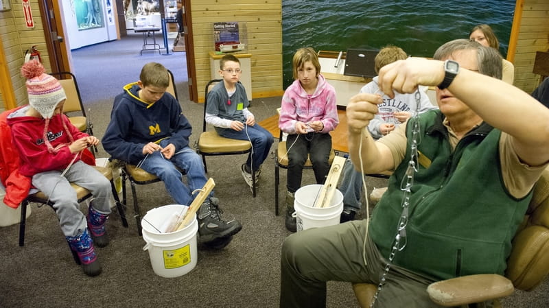 A group of youth learn about ice fishing at the Carl T Johnson Hunt and Fish Center