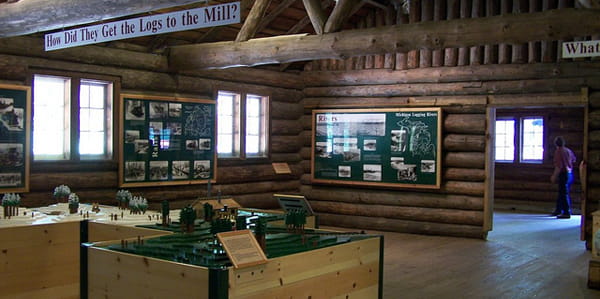Large exhibit panels mounted on the walls of a log building