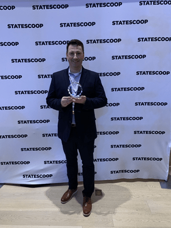 Photo of Rex Menold holding an award.