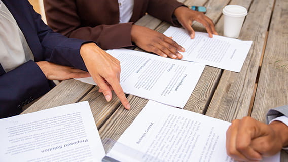 photograph of hands handling business documents on a table