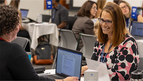 photo of two State of Michigan buyers sitting at a table talking to one another