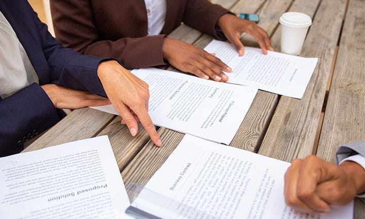 image of hands near bidding documents being reviewed