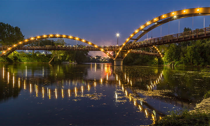 Photograph of the Tridge lit up at night in Midland, Michigan. 