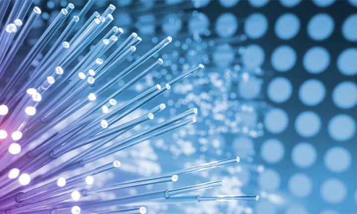 photo of fiber optics network cable over a pattern of repeating circles basked in blue and purple light