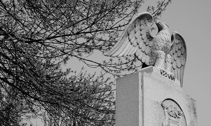 Black and white photo of an eagle sculpture that sits atop the war memorial on the Capitol building lawn in Lansing, Michigan
