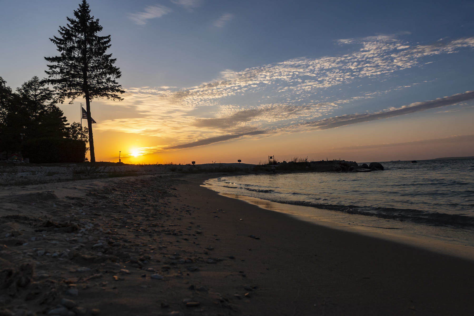 photo of beach at sunset - dark image of beach with orange and red sunset in the background