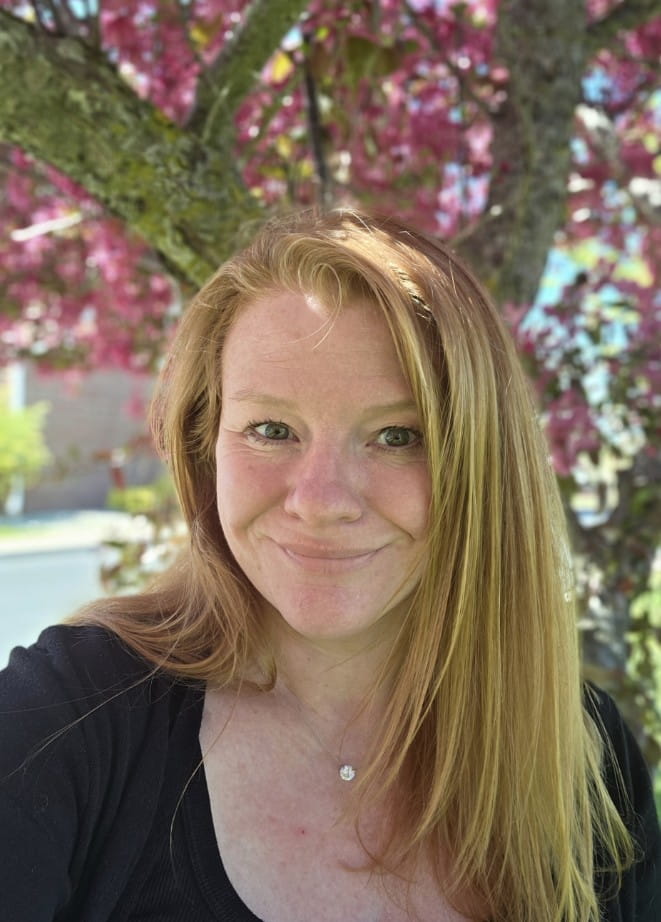 headshot photo of woman from the shoulders up in front of greenery