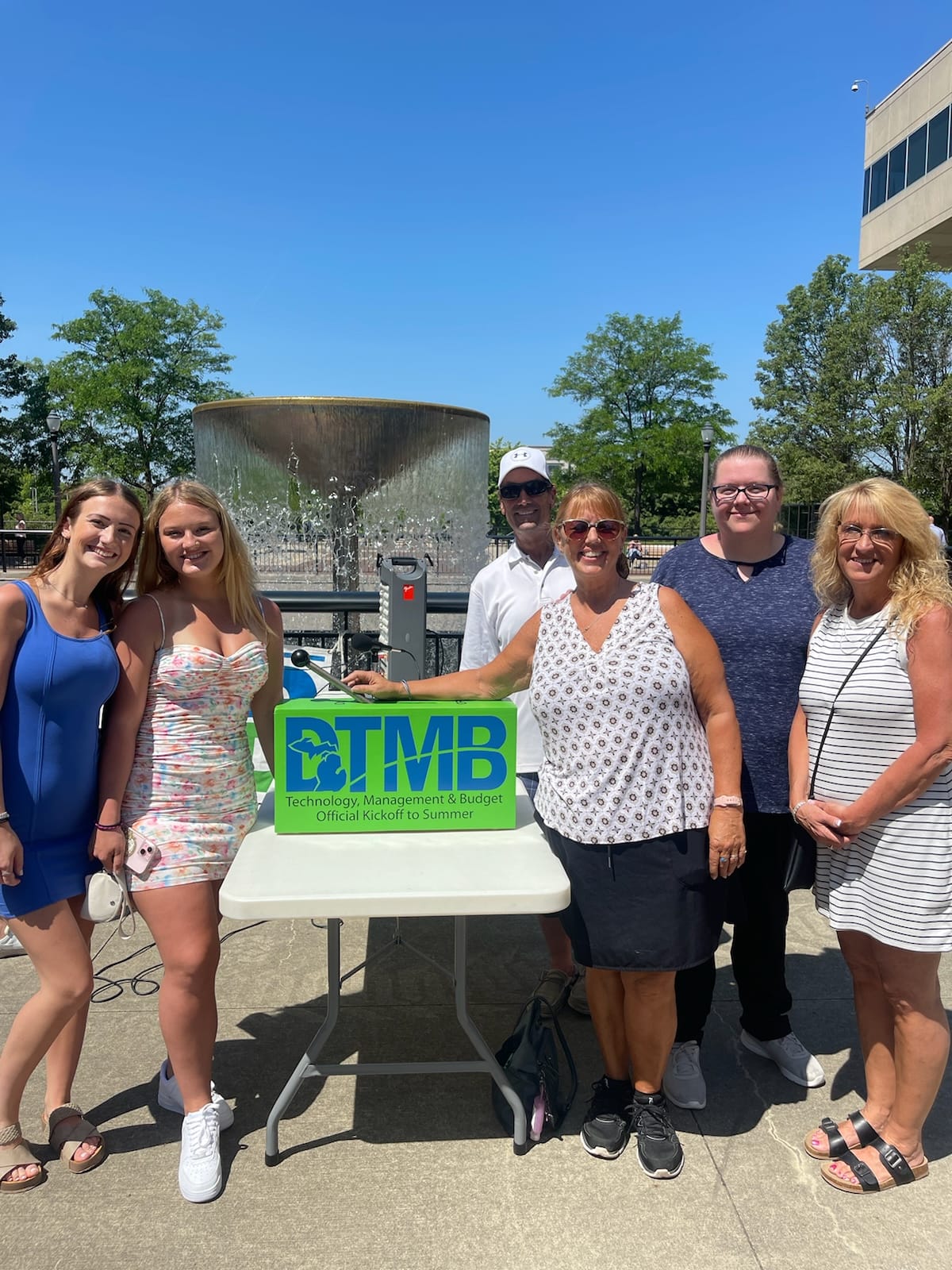 Whiston family posing with the lever with the Brian J. Whiston Memorial Fountain on in the background.