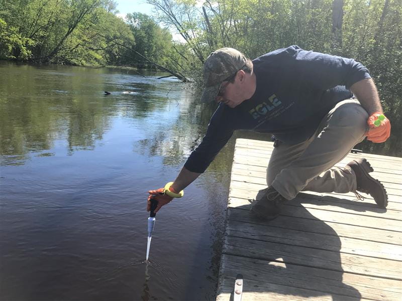 Geoff Rhodes sampling for PFAS from a river. 