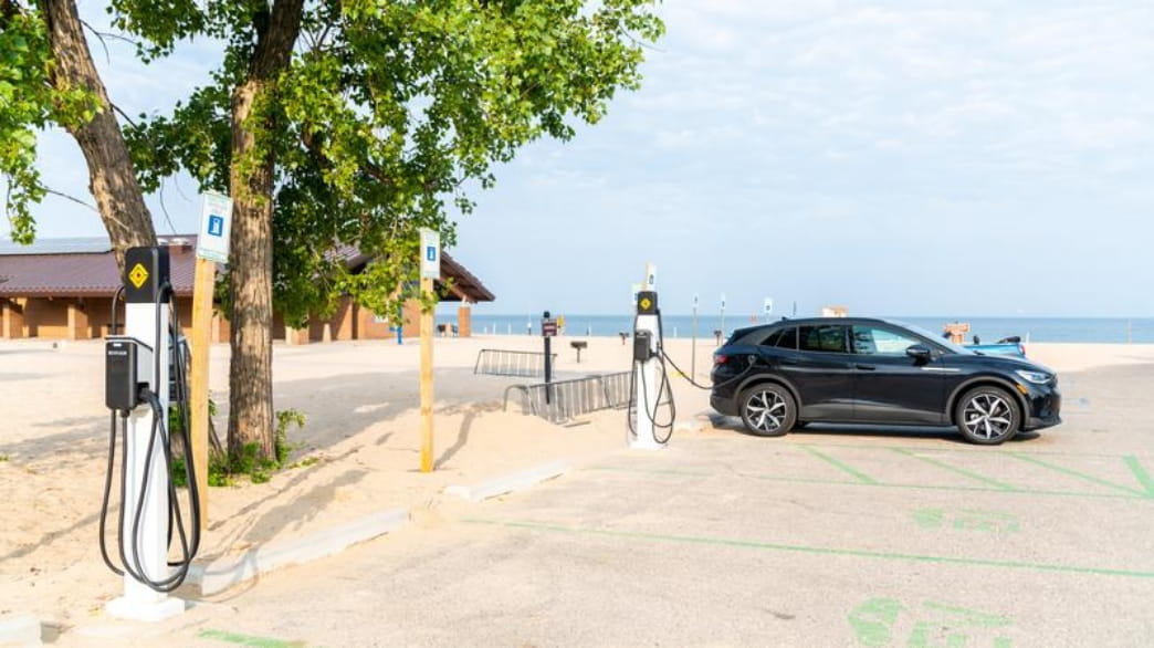 A vehicle getting charged at an electric vehicle charging station at a state park