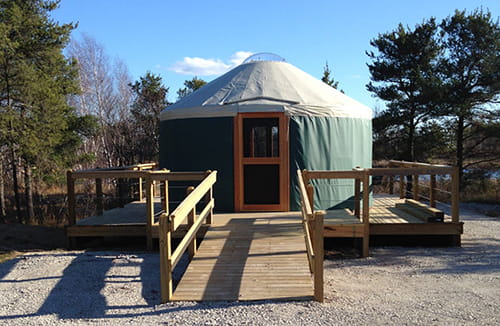 green circular tent with wood ramp
