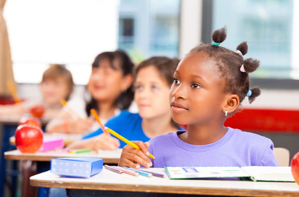 Children listen attentively in a classroom. 
