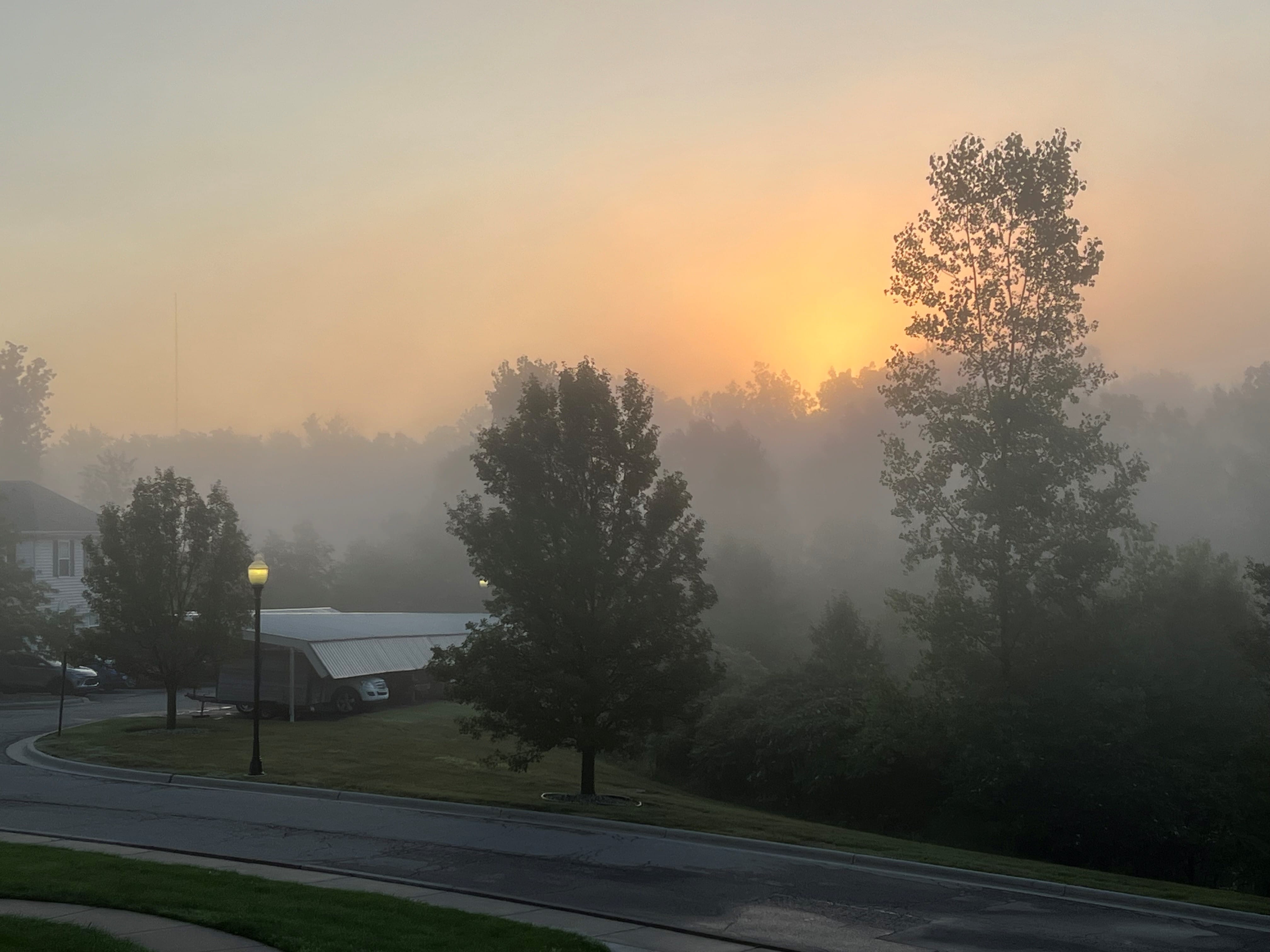 A blazing orange sunrise struggling to be seen through thick layers of wildfire smoke 