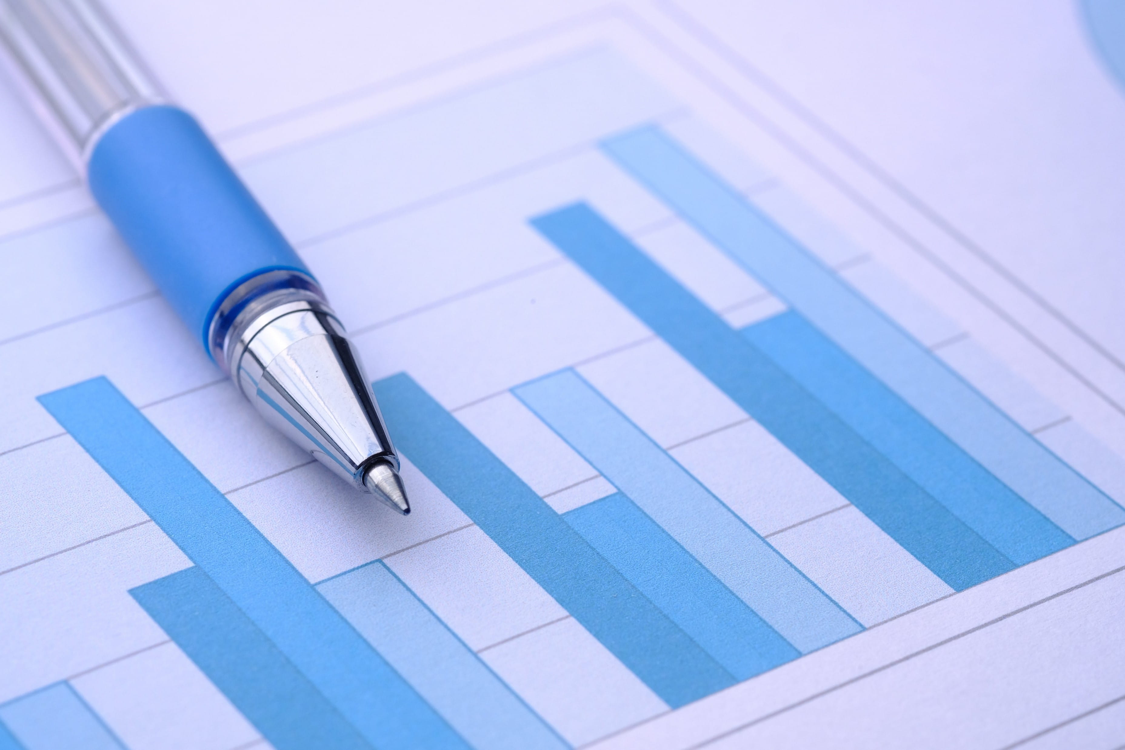 a pen lays on a paper showing a bar graph