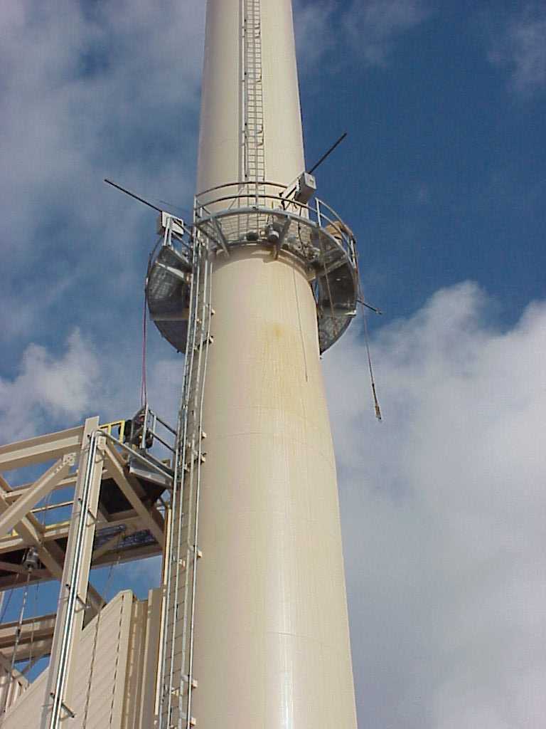 a facility stack with an exterior ladder going up to a platform about half way up
