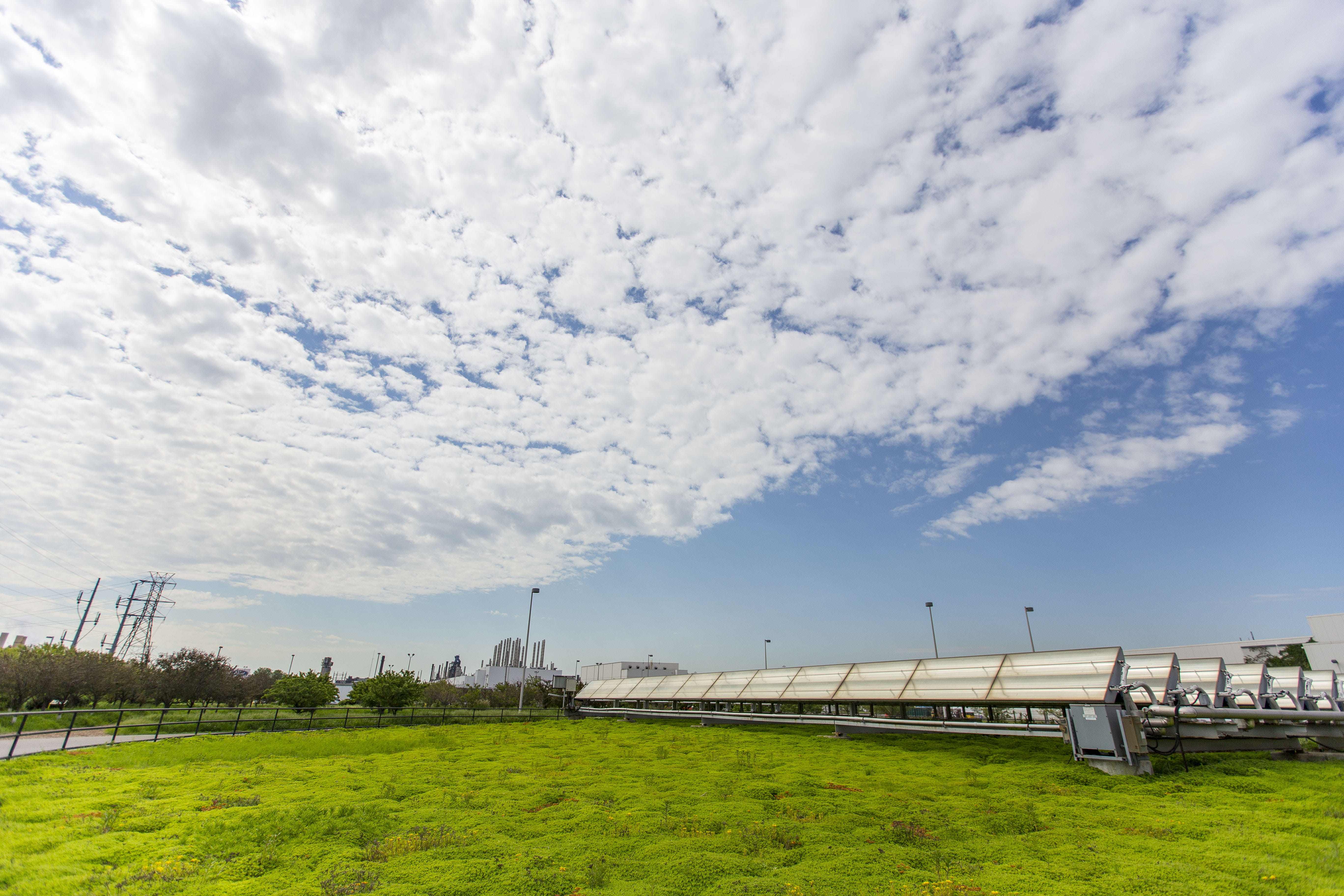 solar panels in a field under a party cloudy sky