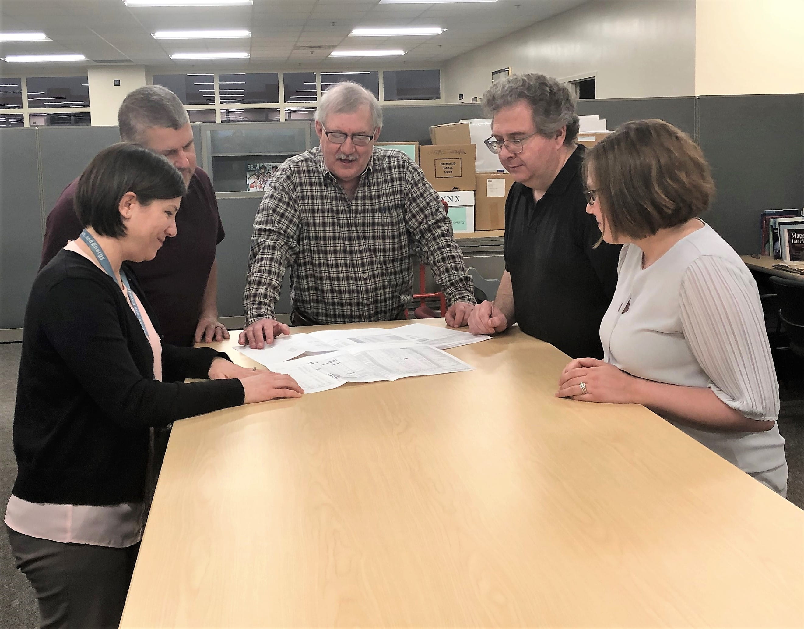 Air Quality Division permit section staff gathered around a table looking at documents.