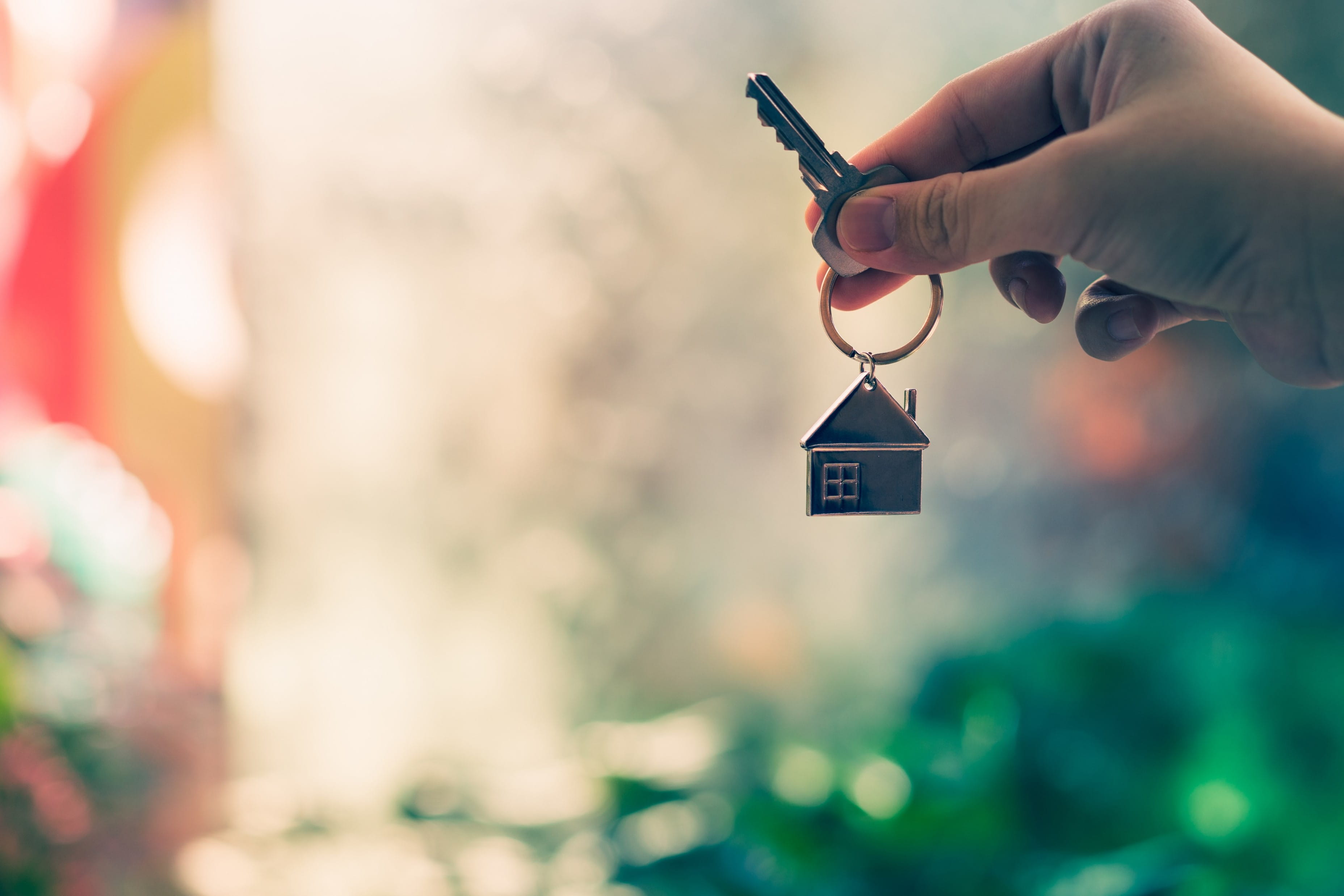 close-up of a hand giving someone the key to a new home