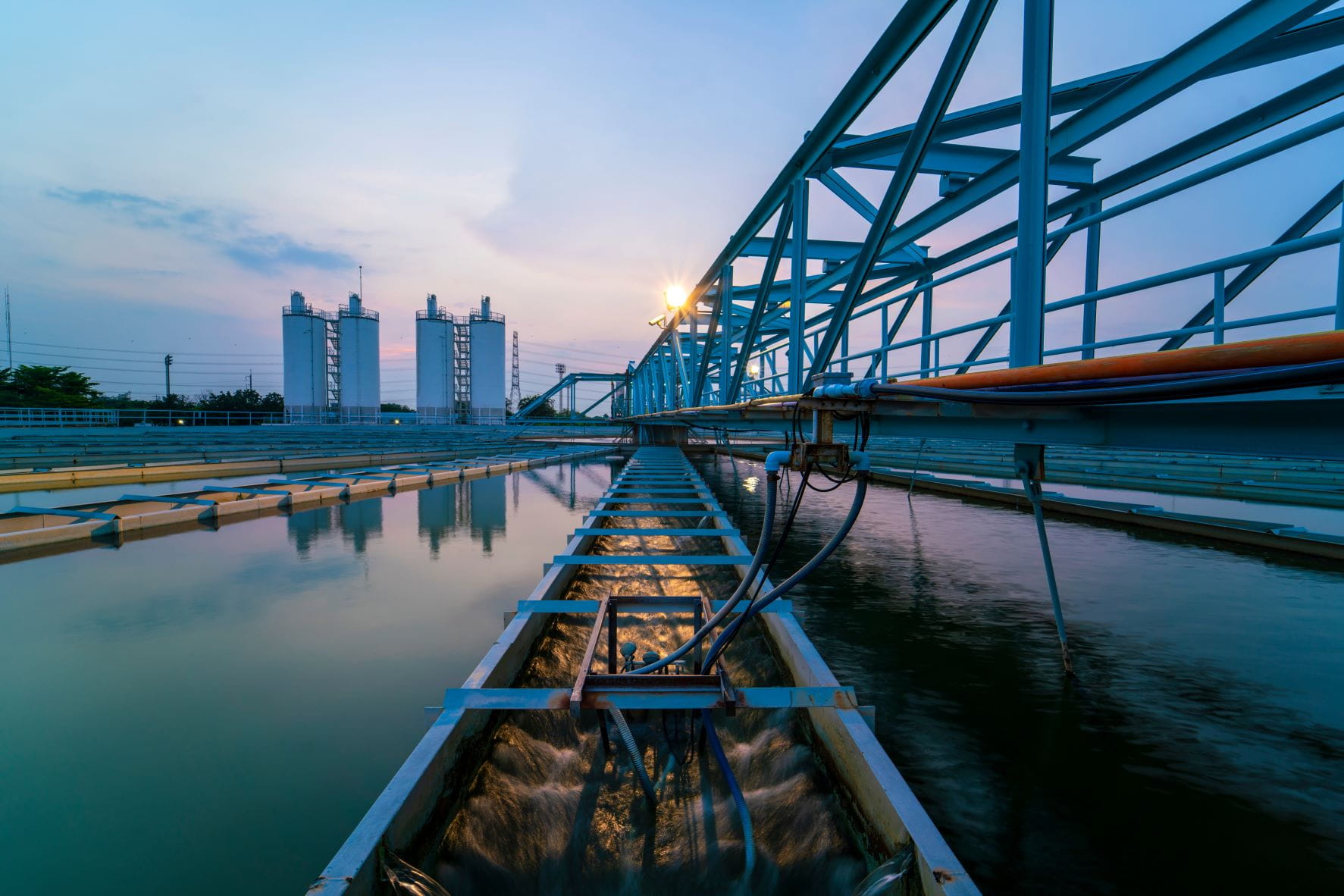 long reservoirs of water under metal railings at sunset