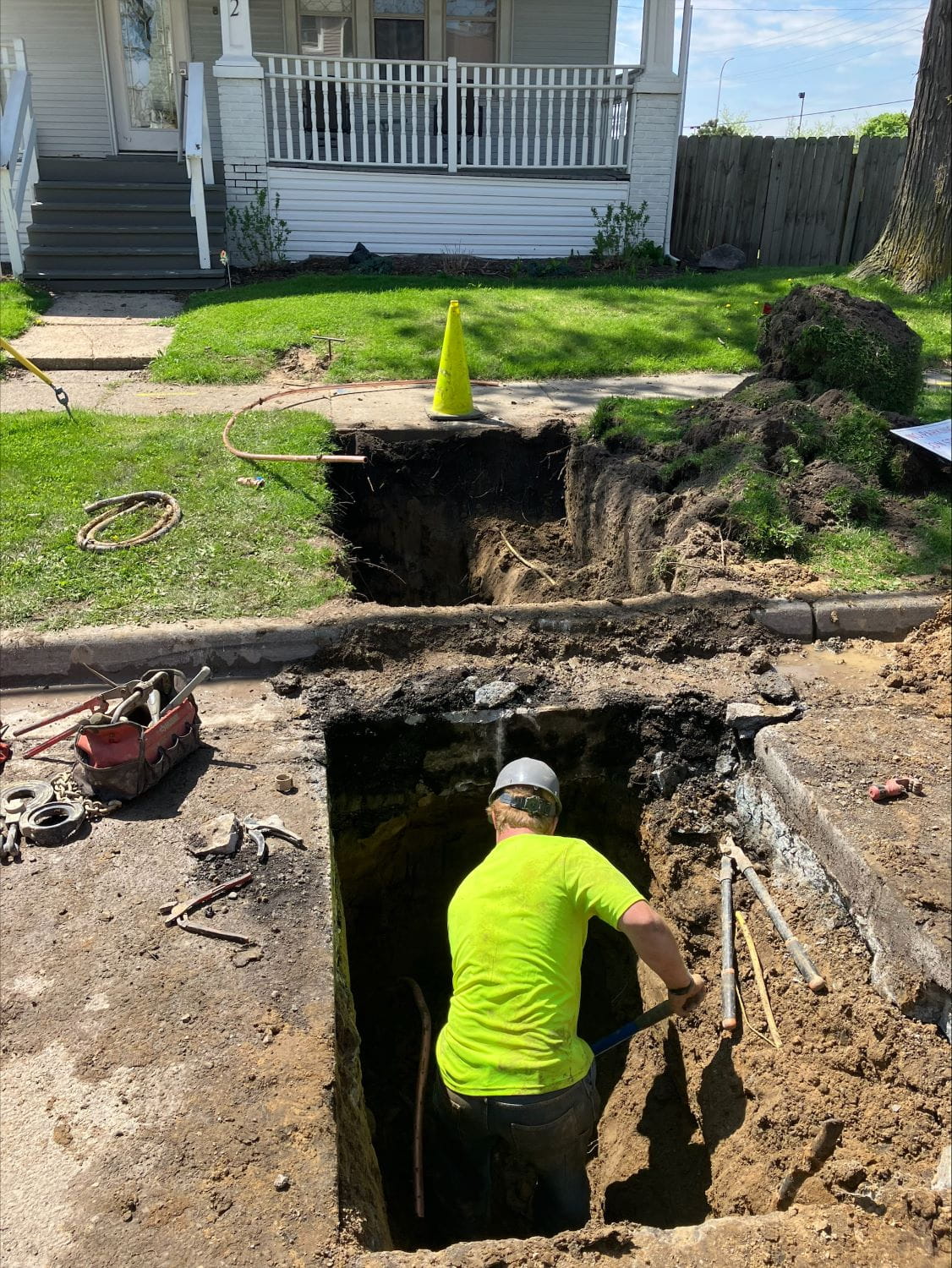 Man digging in a hole as part of the launch of the Get the Lead Out initiative to replace lead service lines.
