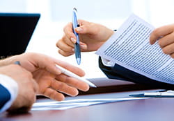 hands holding a pen and a document