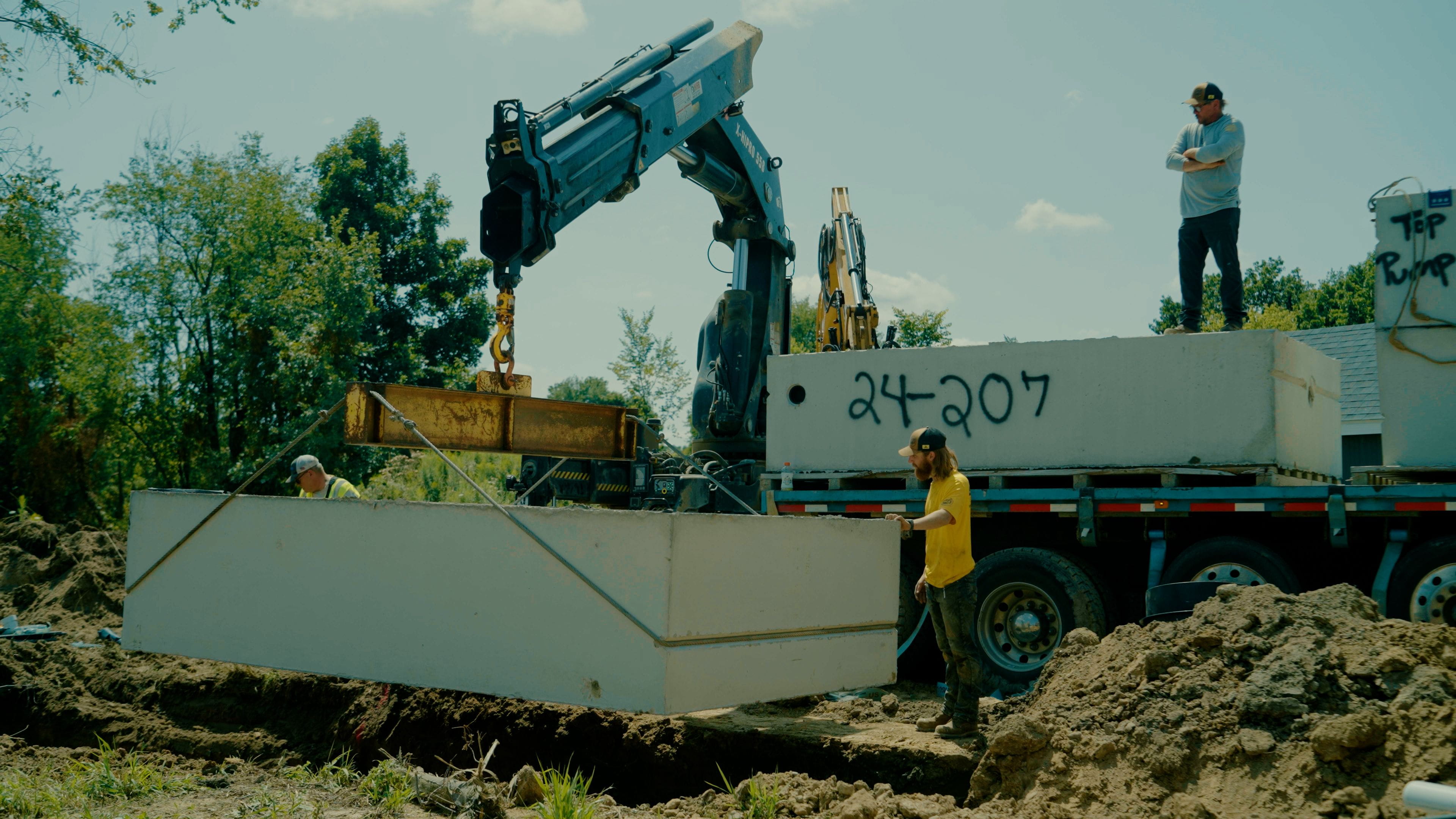 Septic system being replaced with workers using a crane